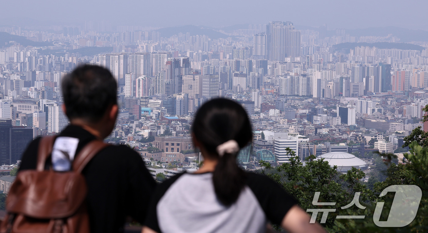 (서울=뉴스1) 박지혜 기자 = 18일 서울 남산을 찾은 관광객이 도심 아파트 단지를 바라보고 있다.최근 한국의 주택가격 양극화 수준이 중국을 제치고 주요국 1위에 오른 것으로 확 …