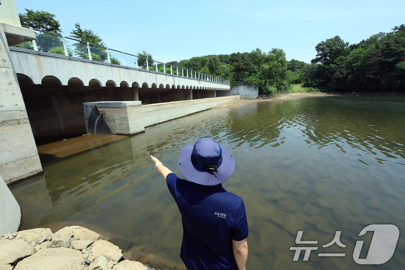 (과천=뉴스1) 박정호 기자 = 송준섭 서울대공원 시설과 주무관이 19일 오후 경기도 과천 서울대공원 내 청계저수지에서 저수율 확보를 위한 수문 가동에 대해 설명하고 있다.서울시는 …