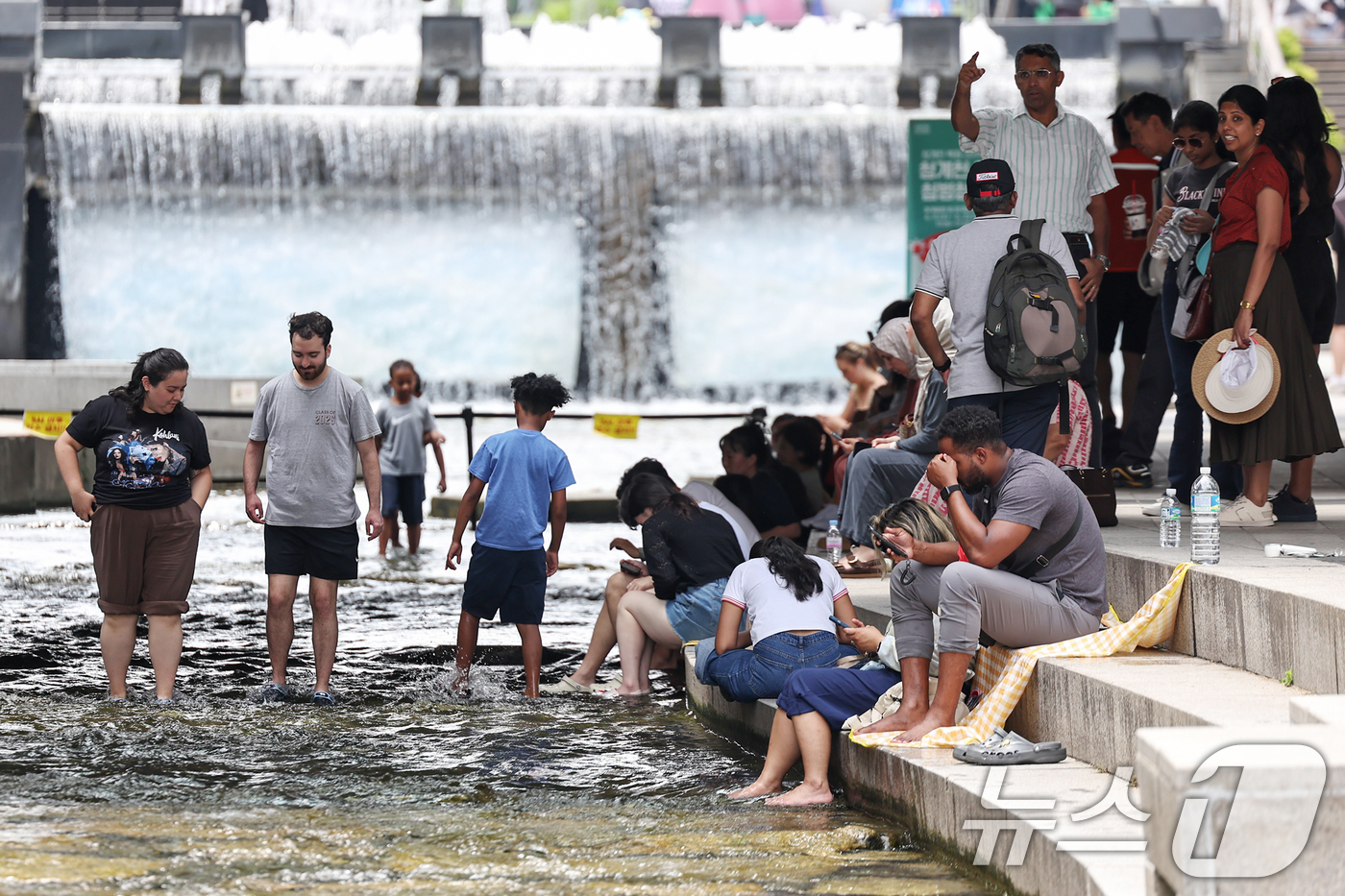 (서울=뉴스1) 민경석 기자 = 서울 지역 낮 최고 기온이 32도까지 올라 무더위가 찾아온 19일 서울중구 청계천에서 외국인 관광객들을 비롯한 어린이들이 물놀이를 하며 더위를 식히 …