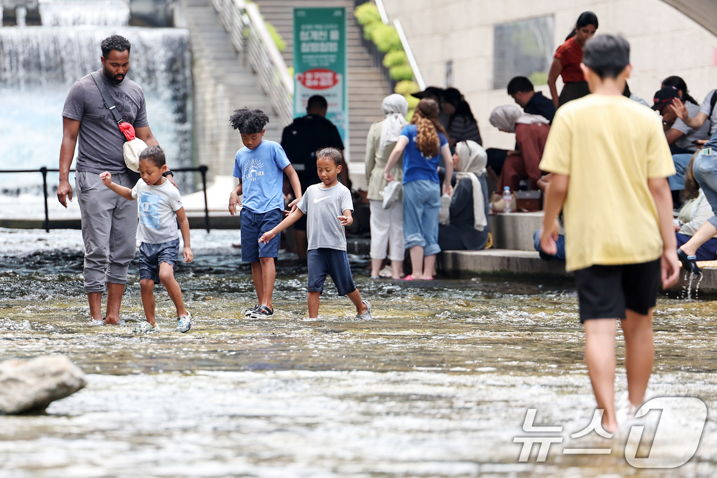 (서울=뉴스1) 민경석 기자 = 서울 지역 낮 최고 기온이 32도까지 올라 무더위가 찾아온 19일 서울중구 청계천에서 외국인 관광객들을 비롯한 어린이들이 물놀이를 하며 더위를 식히 …