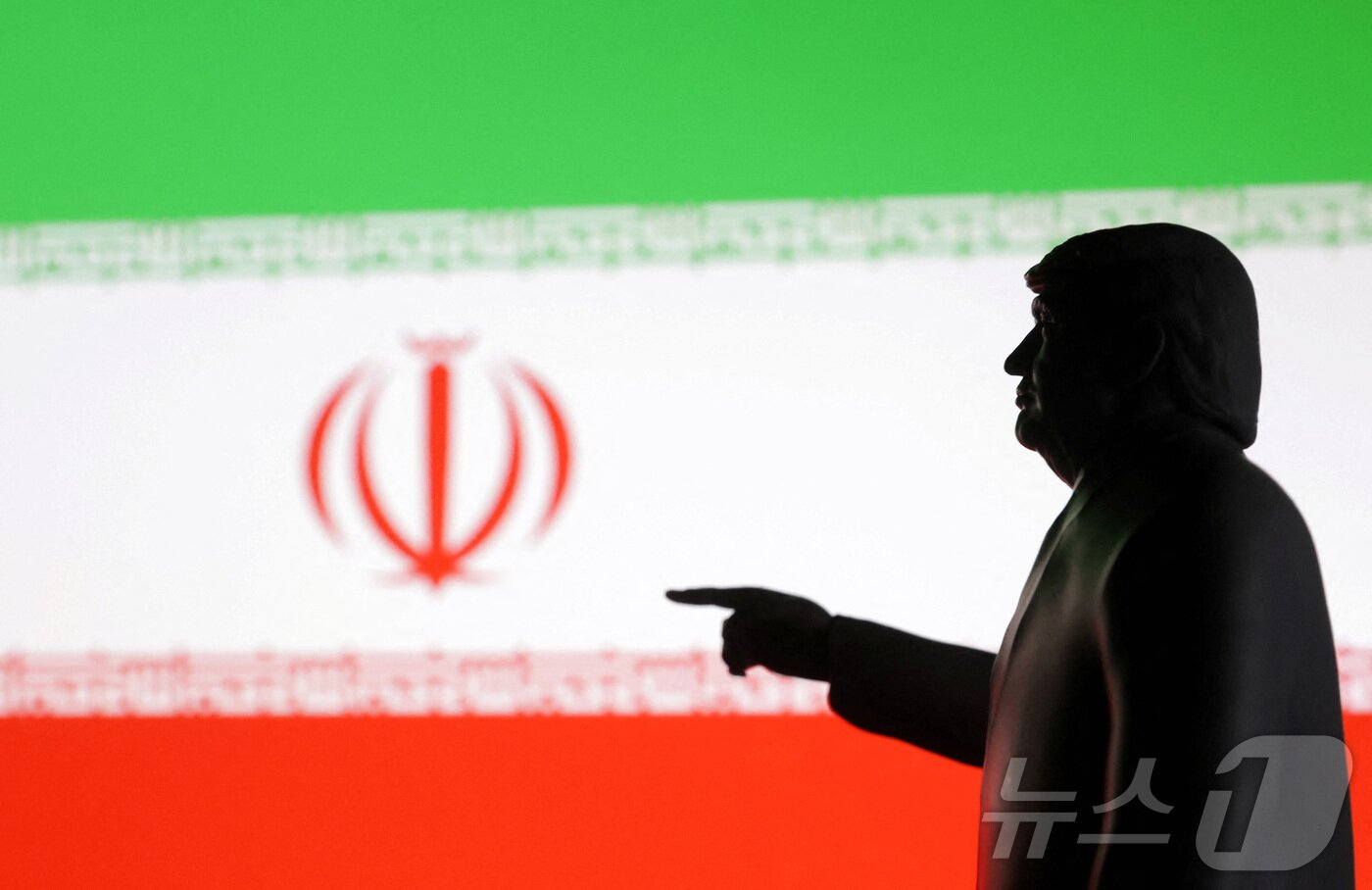 본문 이미지 - 도널드 트럼프 미국 대통령의 뒤로 이란 국기가 펼쳐진 모습. 2025.06.18 ⓒ 로이터=뉴스1 ⓒ News1 김지완 기자