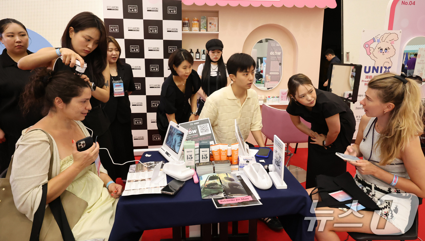 (서울=뉴스1) 장수영 기자 = 19일 오후 서울 중구 DDP에서 열린 2025 코리아뷰티페스티벌를 찾은 외국인 관광객들이 두피 상태를 점검하고 있다. 2025.6.19/뉴스1