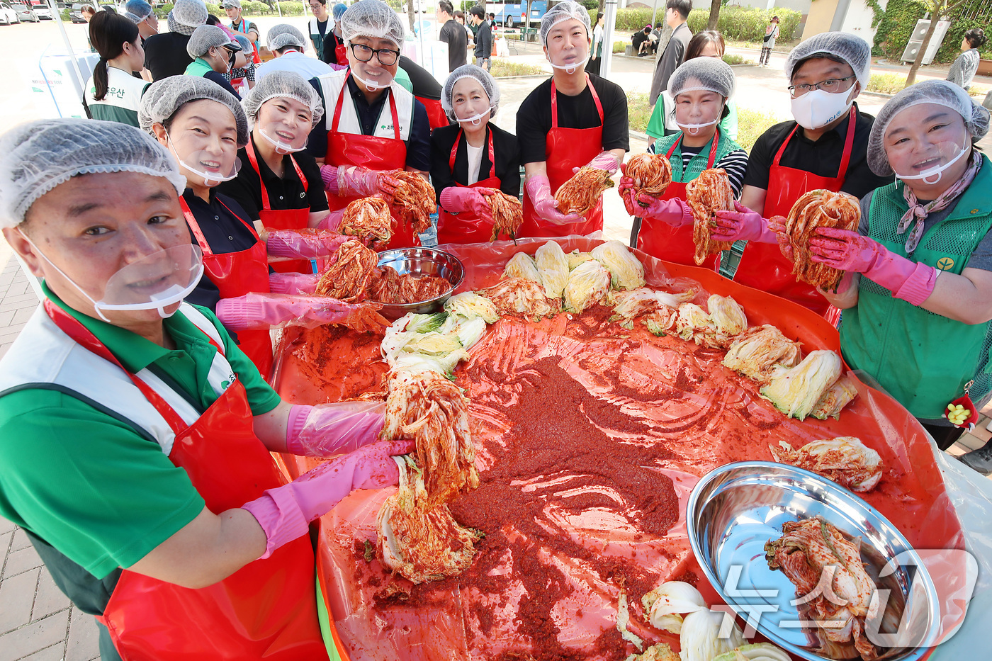 (대구=뉴스1) 공정식 기자 = 19일 대구 동구 율하체육공원에서 열린 '초록우산이 펼치는 초능력 김치 나눔'에 참여한 봉사자들이 정성껏 버무린 김치를 들어 보이고 있다.아동복지전 …
