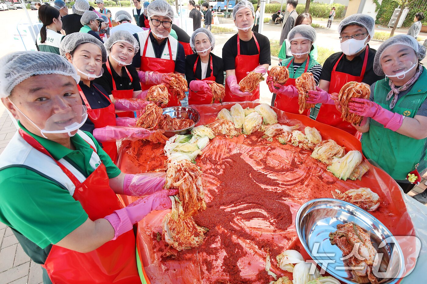 본문 이미지 - 19일 대구 동구 율하체육공원에서 열린 &#39;초록우산이 펼치는 초능력 김치 나눔&#39;에 참여한 봉사자들이 정성껏 버무린 김치를 들어 보이고 있다. 2025.6.19/뉴스1 ⓒ News1 공정식 기자