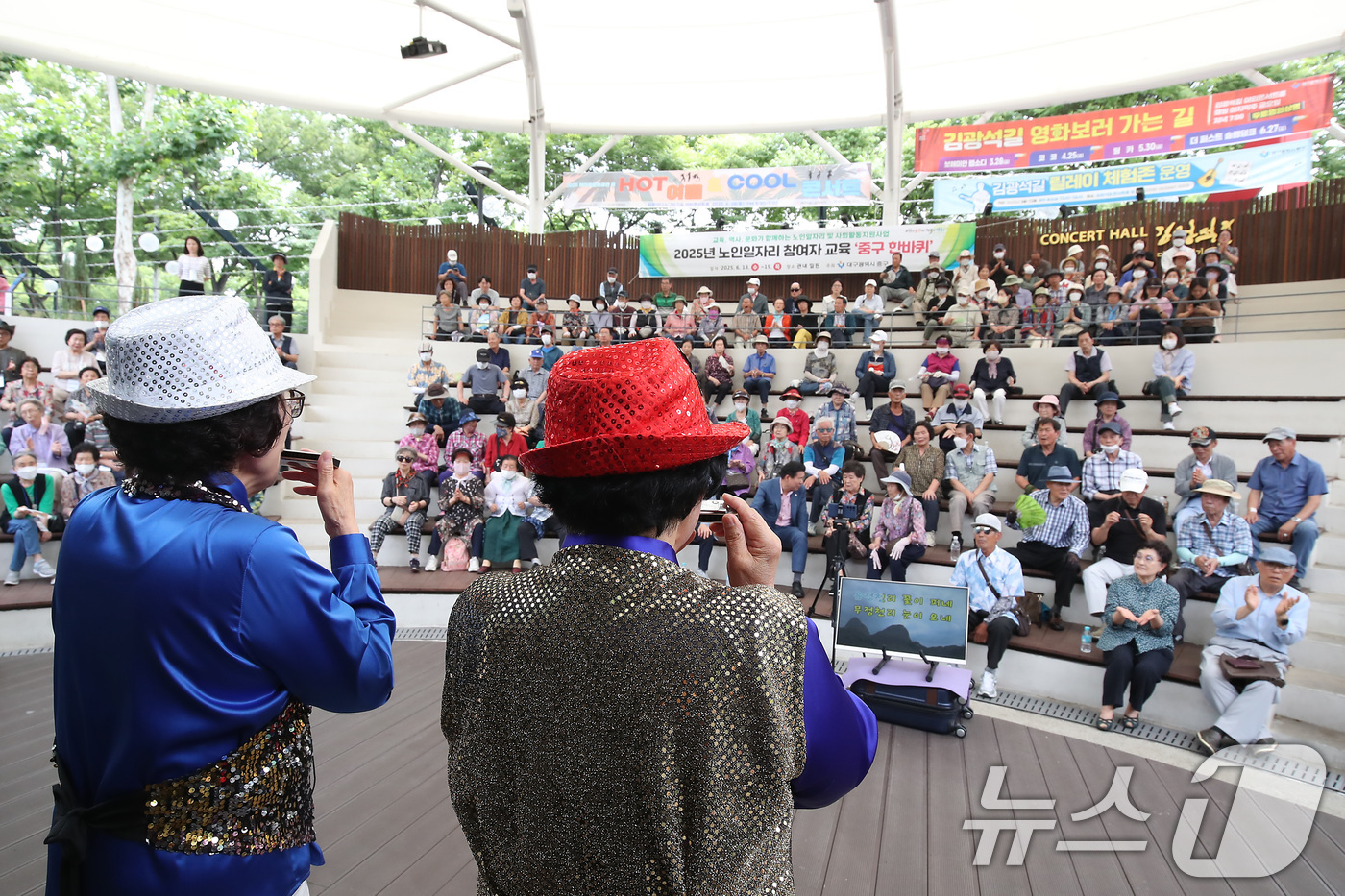 (대구=뉴스1) 공정식 기자 = 19일 대구 중구 김광석길 야외콘서트홀에서 열린 '노인일자리 참여자를 위한 중구 한바퀴'에 참여한 어르신들이 공연을 관람하고 있다.김광석길에서는 교 …