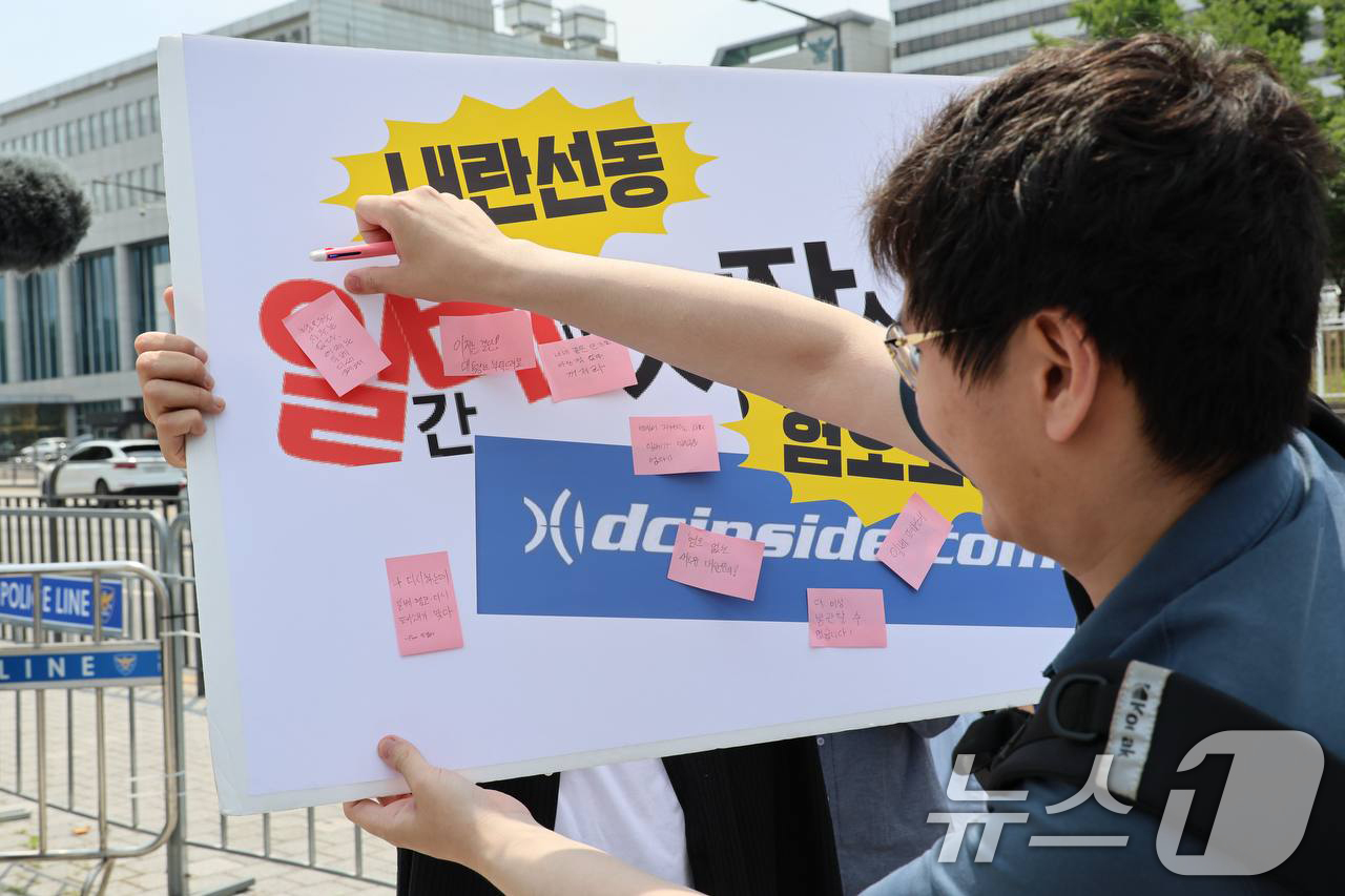(서울=뉴스1) = 19일 서울 용산 대통령실 앞에서 열린 진보당 '일베폐쇄 서명 11만 대통령실 전달 기자회견'에서 참석자가 일베 폐쇄를 촉구하는 메모를 붙이고 있다. (진보당 …