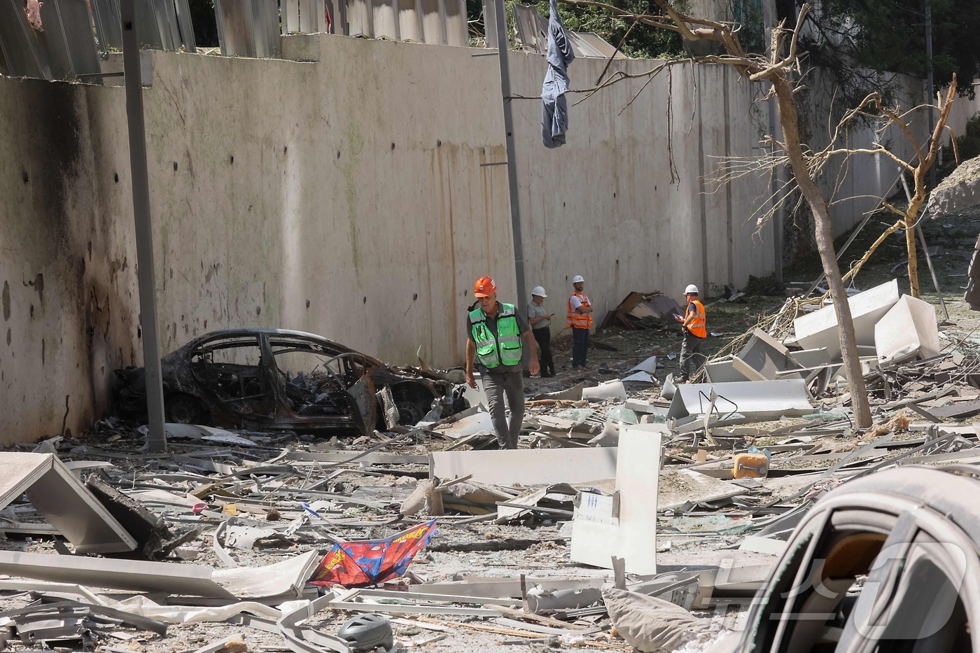 (라마트간 AFP=뉴스1) 김지완 기자 = 19일(현지시간) 이란의 공격으로 인해 피해를 입은 이스라엘 텔아비브 근처 라마트간의 한 거리에서 구조대가 현장을 살펴보고 있다. 202 …