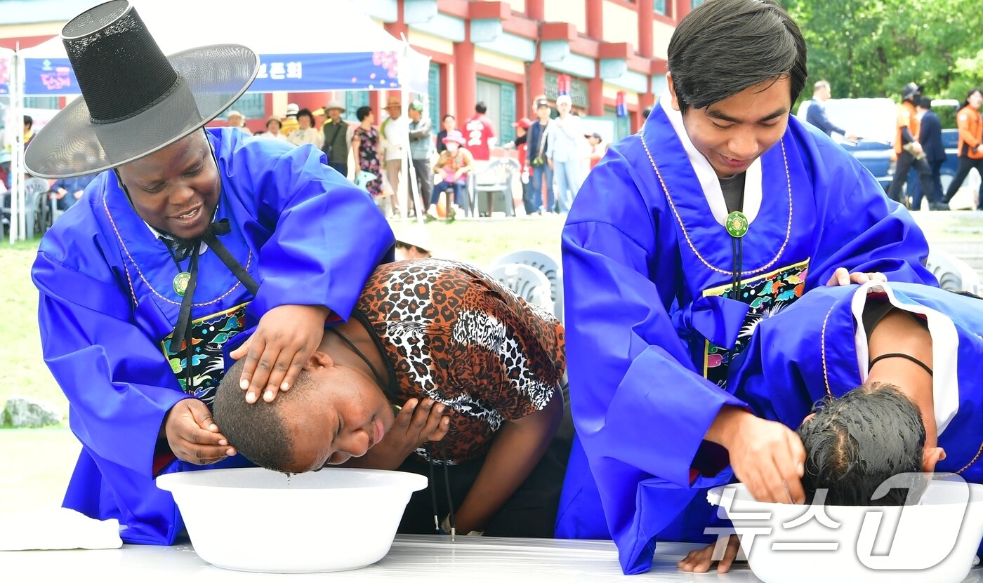 본문 이미지 - 지난 1일 열린 자인단오제 '외국인 유학생 창포머리감기 시연'행사에 참여한 외국인 학생들이 창포물에 머리를 감는 체험을 하고 있다.(경산시 제공. 재판매 및 DB금지) 2025.6.2/뉴스1 ⓒ News1 정우용 기자