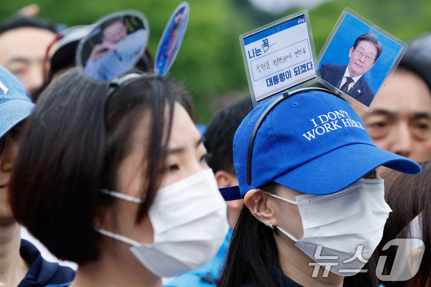 (서울=뉴스1) 안은나 기자 = 제21대 대통령선거를 하루 앞둔 2일 오전 서울 강북구 북서울꿈의숲 서문광장에서 이재명 더불어민주당 대통령 후보 지지자가 이 후보 사진이 담긴 머리 …