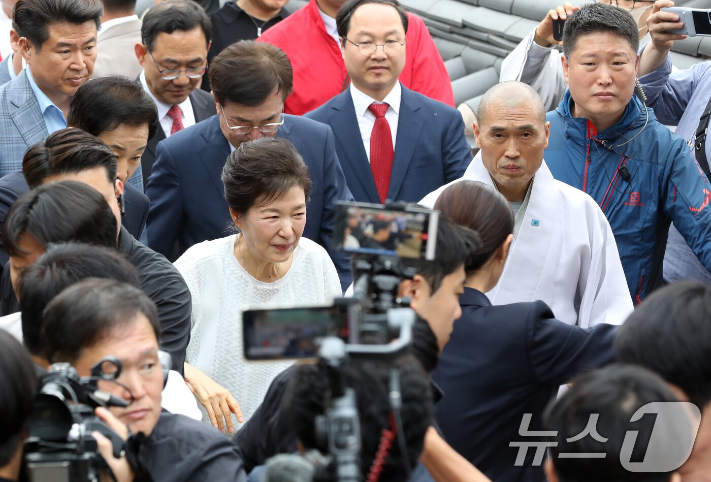 본문 이미지 - 박근혜 전 대통령이 2일 부산 금정구 범어사를 방문해 주지 정오스님과 이동하며 지지자들에게 인사하고 있다. 2025.6.2/뉴스1 ⓒ News1 윤일지 기자