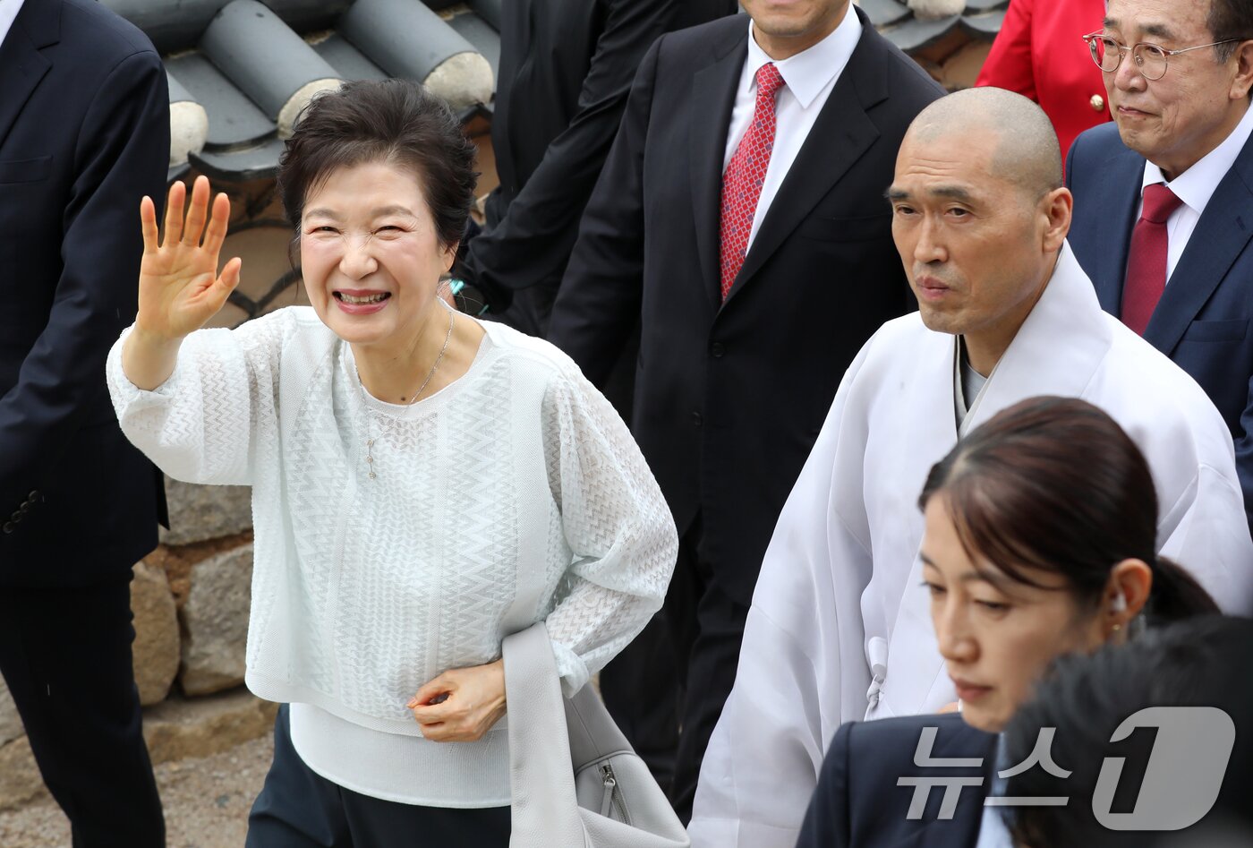 본문 이미지 - 박근혜 전 대통령이 2일 부산 금정구 범어사를 방문해 주지 정오스님과 대웅전으로 향하며 지지자들에게 인사하고 있다. 2025.6.2/뉴스1 ⓒ News1 윤일지 기자