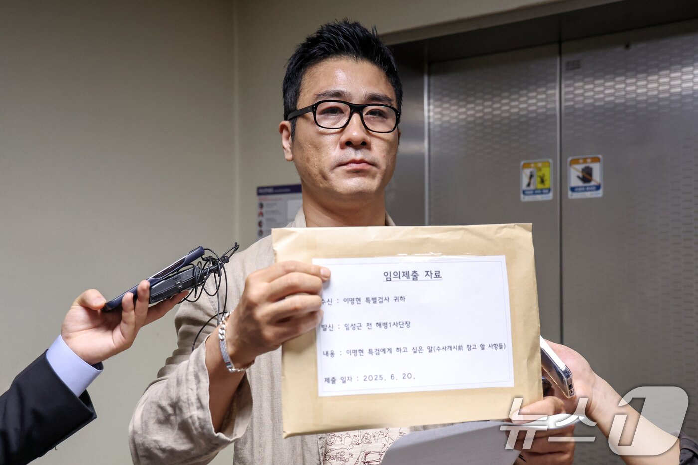 본문 이미지 - 임성근 전 해병대 1사단장 구명 로비 의혹의 최초 제보자라고 밝힌 이관형 씨가 20일 오전 순직 해병 수사 방해 의혹 사건 수사를 맡은 이명현 특별검사의 서울 서초구 사무실을 찾아 이 특검에게 전달하려 했던 자료를 들어보이고 있다. 이 씨는 "수사 개시 전 참고해야 할 사항을 총 15개 문서 77쪽의 자료 5부로 준비했고 임 전 사단장을 대신해 전달하려 한다＂고 밝혔다. 한 편 이 특검은 이날 이 씨가 면담을 요구한 것과 관련해 ＂들은 바가 없기 때문에 나중에 필요하면 하겠다＂고 취재진에게 입장을 밝혔다. 2025.6.20/뉴스1 ⓒ News1 민경석 기자