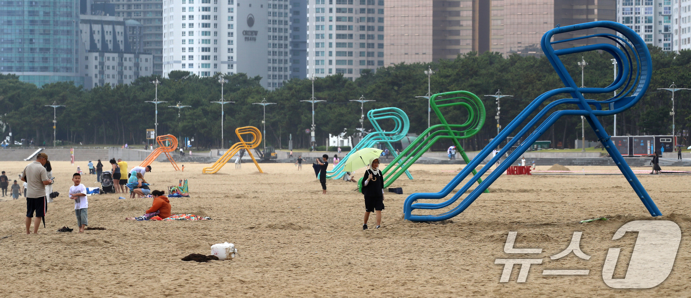 (부산=뉴스1) 윤일지 기자 = 20일 부산 해운대해수욕장 개장을 앞두고 설치된 망루 옆으로 관광객들이 해변을 거닐고 있다.부산 해운대·송정해수욕장은 오는 21일 개장하고, 광안리 …