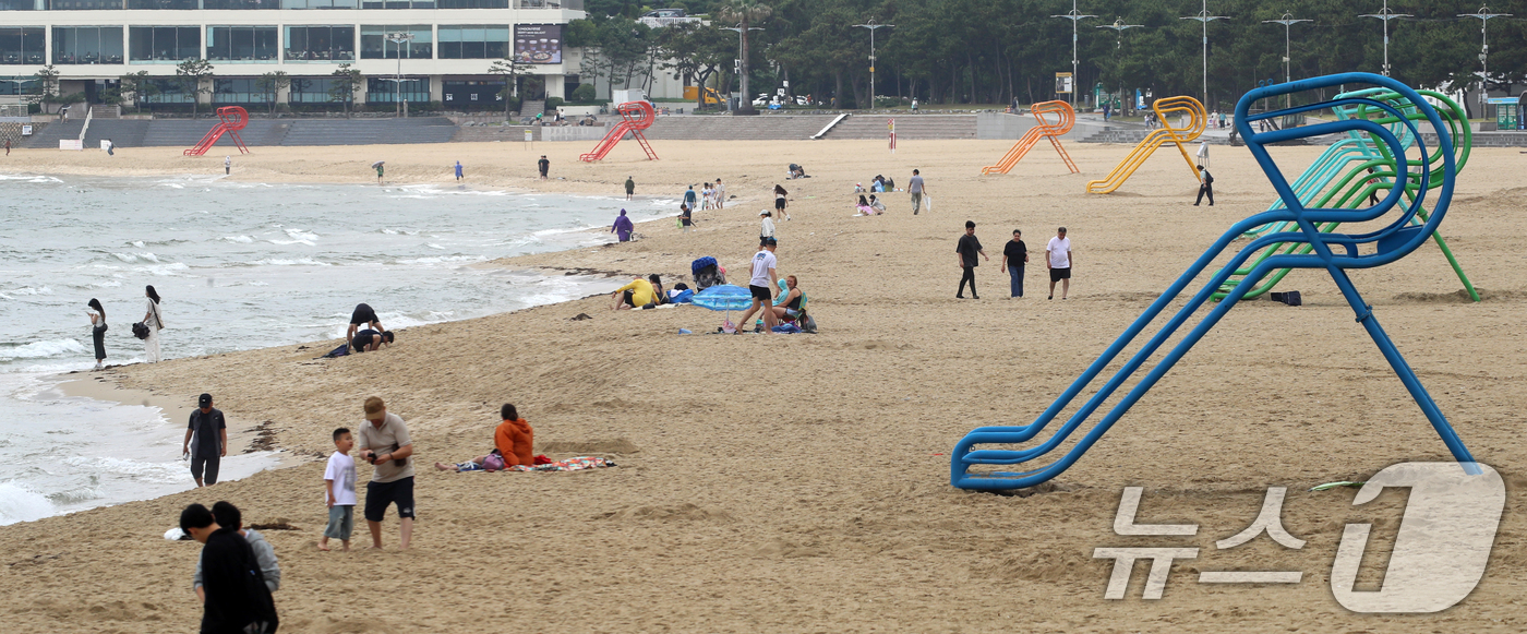 (부산=뉴스1) 윤일지 기자 = 20일 부산 해운대해수욕장 개장을 앞두고 설치된 망루 옆으로 관광객들이 해변을 거닐고 있다.부산 해운대·송정해수욕장은 오는 21일 개장하고, 광안리 …