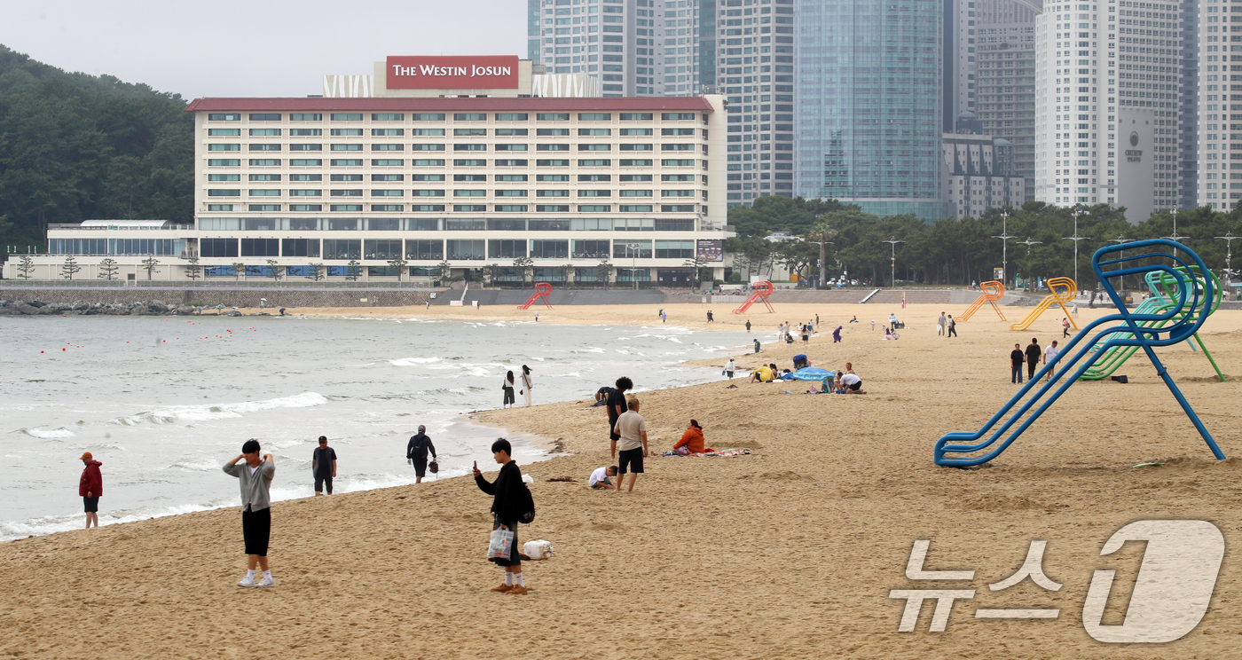 (부산=뉴스1) 윤일지 기자 = 20일 부산 해운대해수욕장 개장을 앞두고 설치된 망루 옆으로 관광객들이 해변을 거닐고 있다.부산 해운대·송정해수욕장은 오는 21일 개장하고, 광안리 …