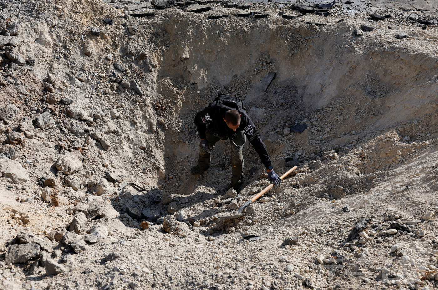 (베르셰바 로이터=뉴스1) 김지완 기자 = 20일(현지시간) 이스라엘 베르셰바의 땅에 이란의 미사일 공격으로 인해 구멍이 생긴 모습. 2025.06.20ⓒ 로이터=뉴스1