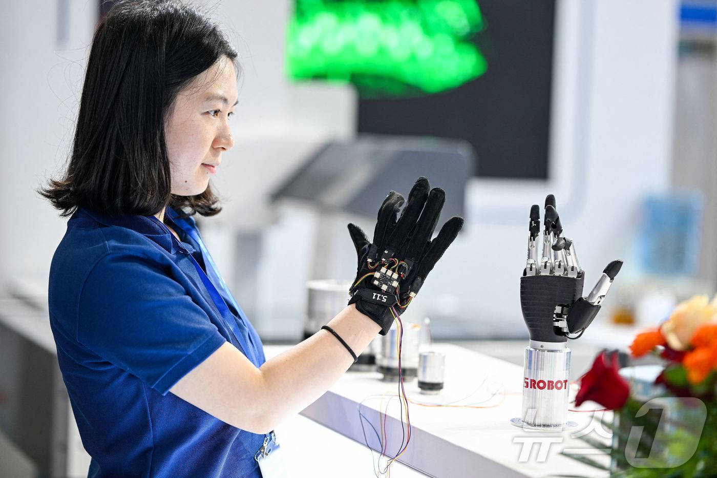 (난징 AFP=뉴스1) 신기림 기자 = 2025년 6월 20일 중국 동부 장쑤성 난징에서 열린 2025 세계 반도체 컨퍼런스- 엑스포에서 한 직원이 촉각 장갑을 사용하여 생체공학 …