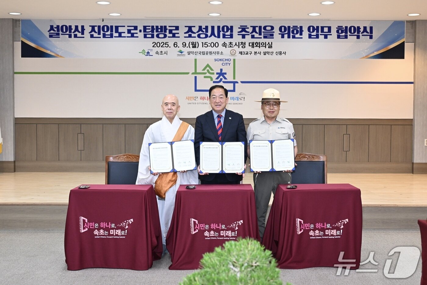 본문 이미지 - 지난 9일 오후 강원 속초시청 대회의실에서 열린 설악산 '진입도로·탐방로 조성을 위한 관계기관 협약식'에서 이병선 시장(사진 가운데)과 대한불교 조계종 제3교구 본사 신흥사 주지 스님(사진 왼쪽), 현병관 국립공원공단 설악산사무소장이 협약서를 들고 기념촬영을 하고 있다.(속초시 제공, 재판매 및 DB 금지)