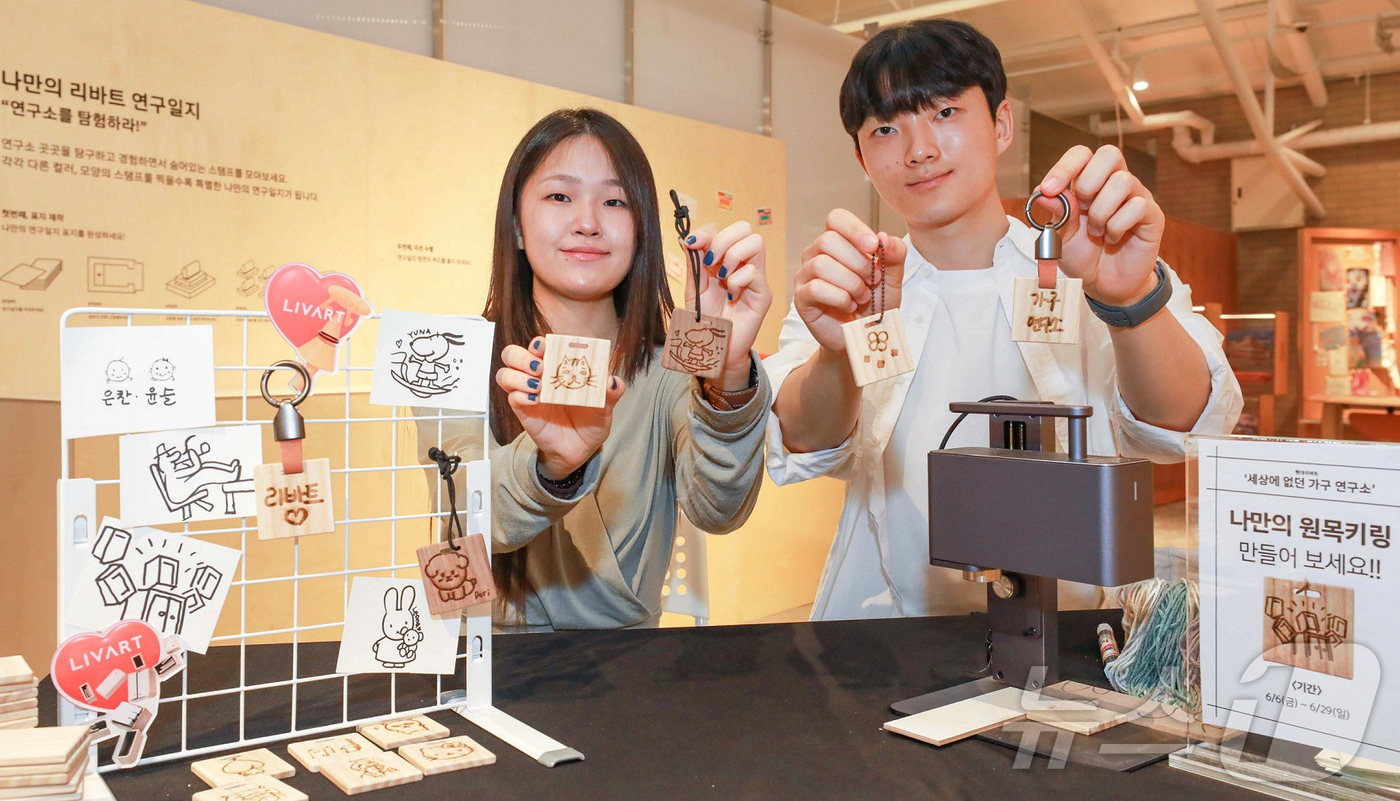 (서울=뉴스1) = 22일 오전 서울 성동구 현대리바트 '세상에 없던 가구 연구소' 팝업스토어에서 직원들이 '나만의 원목 키링' 이벤트를 소개하고 있다.  (현대백화점그룹 제공. …