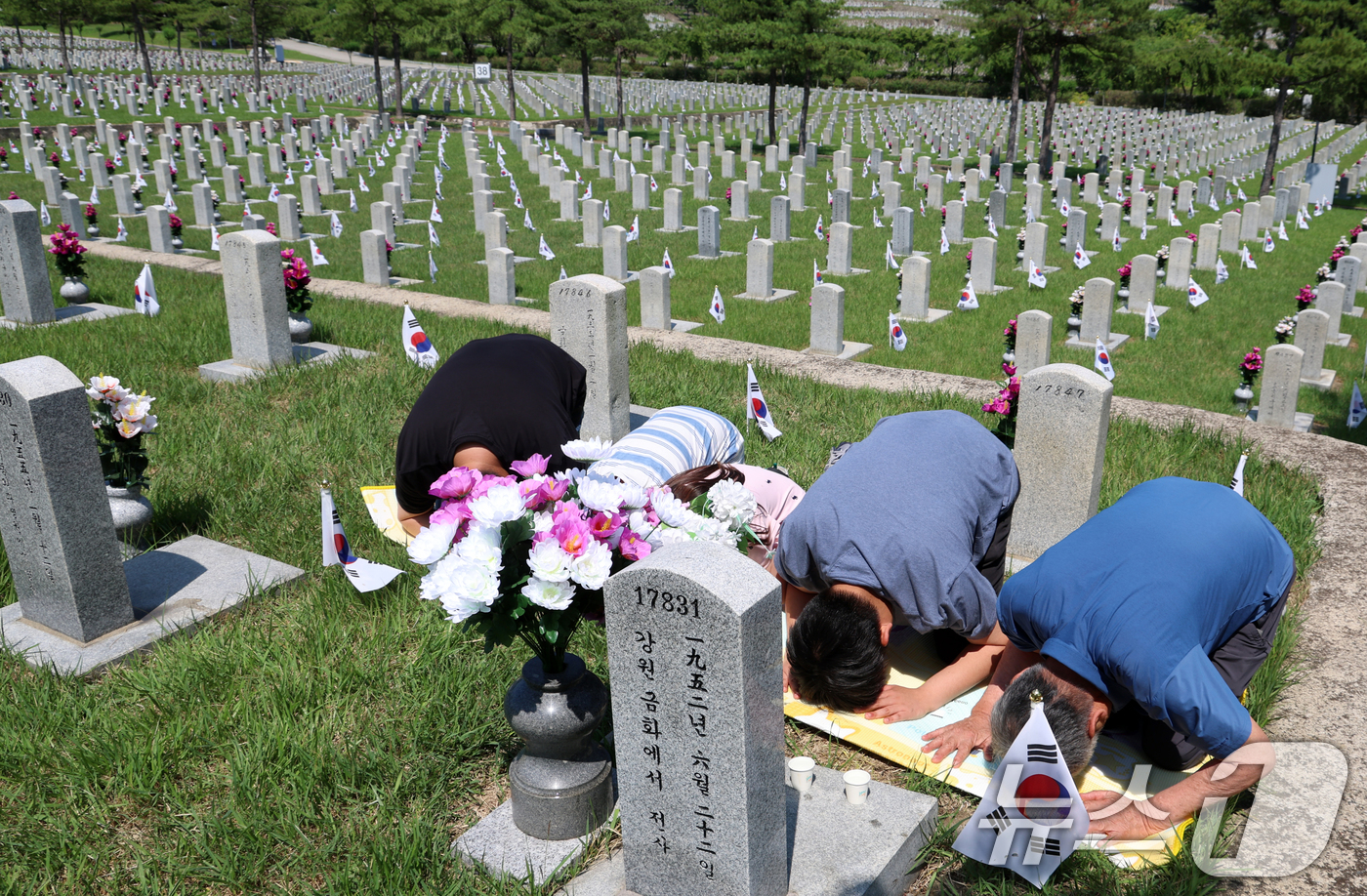 (서울=뉴스1) 김명섭 기자 = 6·25전쟁 75주년을 사흘앞둔 22일 서울 동작구 국립서울현충원 묘역에서  6·25전쟁 전사자 유족들이 참배를 하고 있다.  2025.6.22/뉴 …