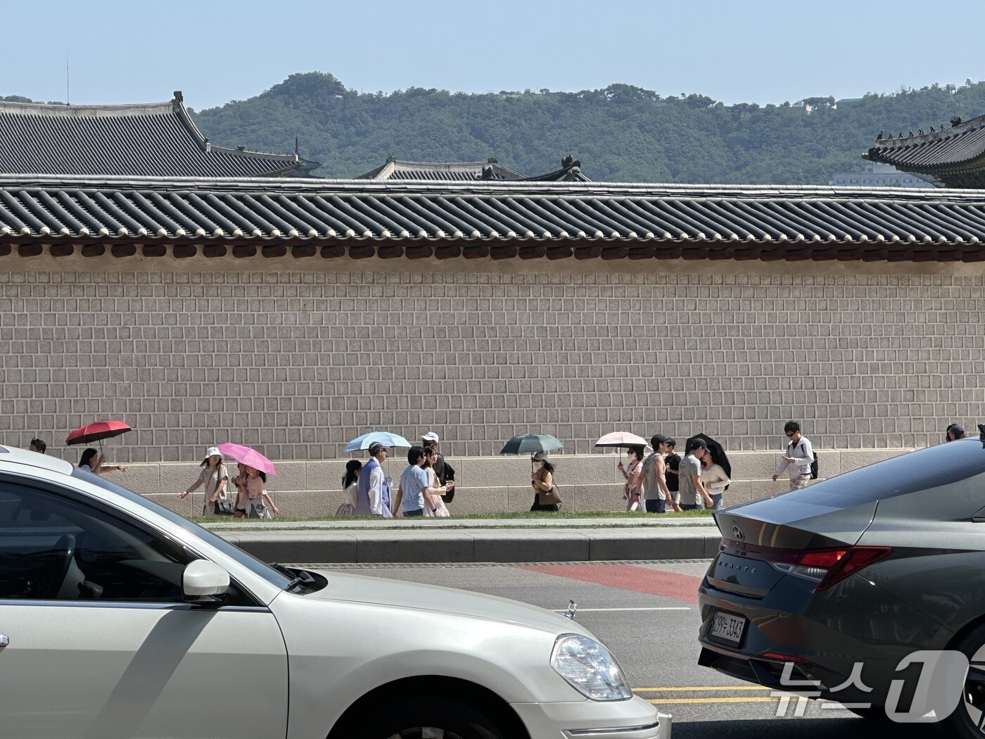 본문 이미지 - 22일 오전 서울 종로구 경복궁 앞 모습. 시민들이 형형색색의 양산을 쓰고 걸어가고 있다. ⓒ 뉴스1 강서연 기자