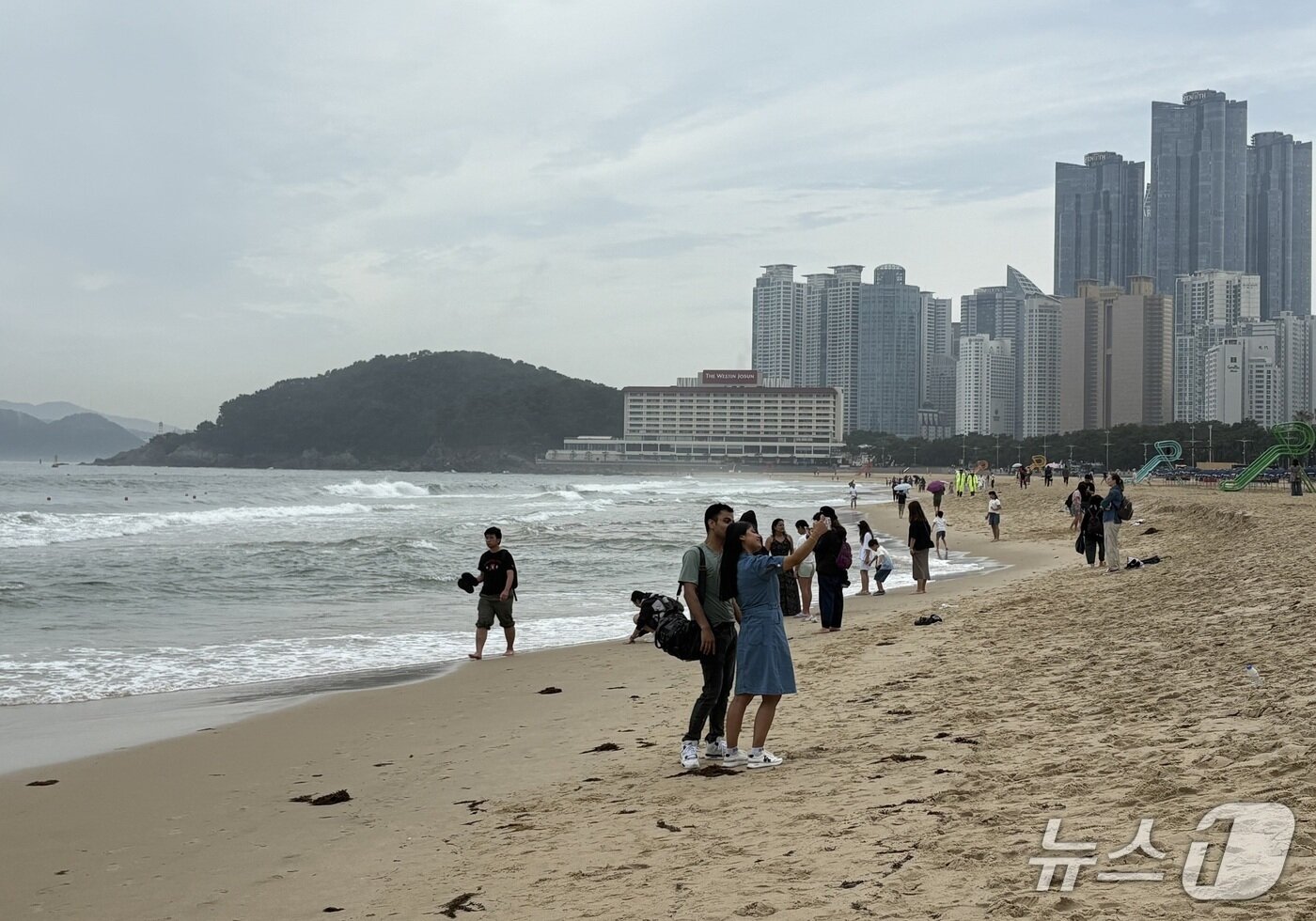 본문 이미지 - 22일 부산 해운대 해수욕장을 찾은 피서객들이 기념사진을 촬영하고 있다.2025.6.22/뉴스1 강미영기자