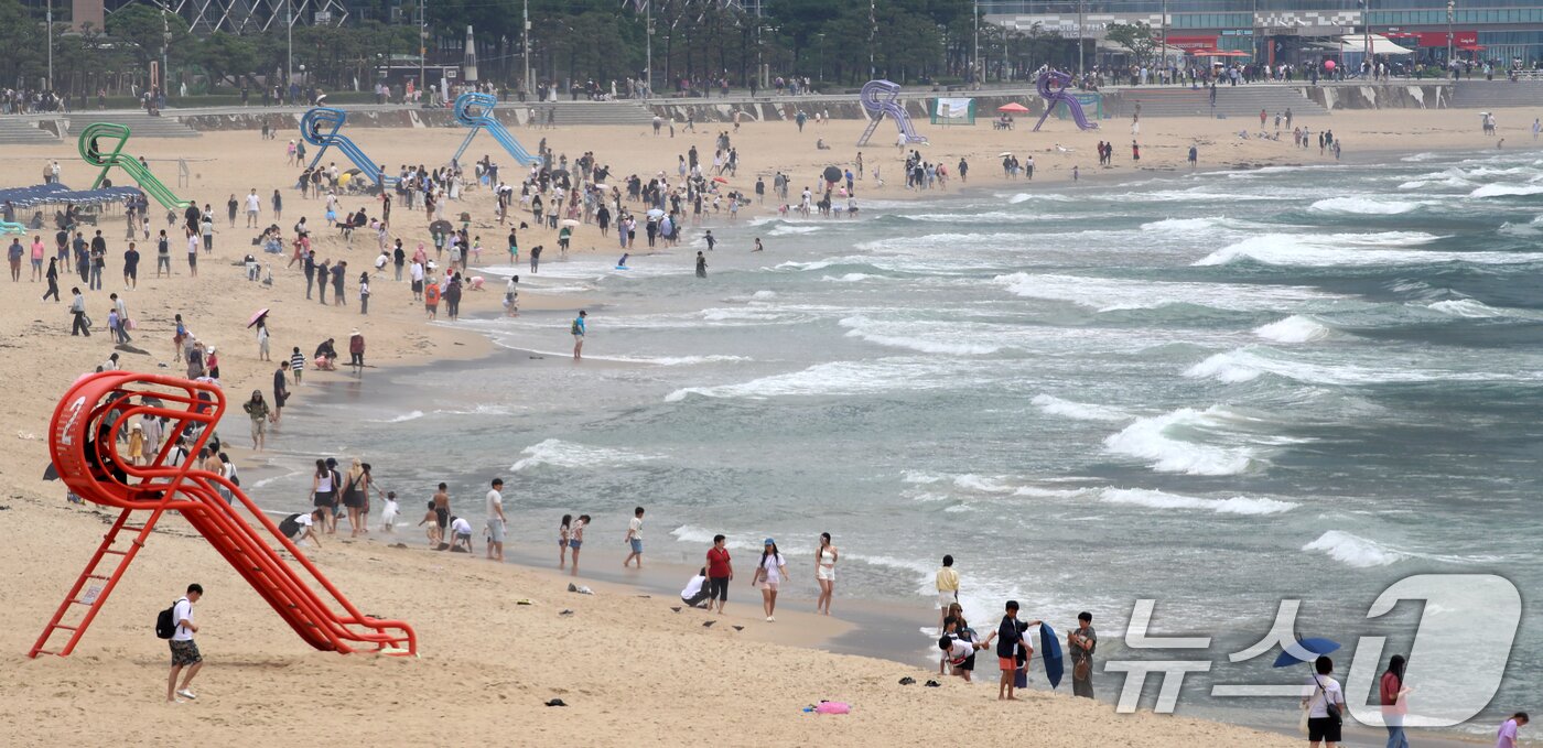 본문 이미지 - 부산 해운대해수욕장이 개장한 후 첫 주말을 맞은 22일 해운대해수욕장을 찾은 관광객과 시민들이 물놀이를 즐기며 더위를 식히고 있다. 2025.6.22/뉴스1 ⓒ News1 윤일지 기자