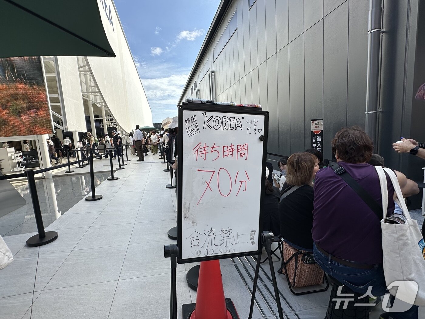 본문 이미지 - 한국 파빌리온을 관람하기 위해 뙤약볕 아래 한없이 기다리고 있는 관람객들ⓒ News1 윤슬빈 기자