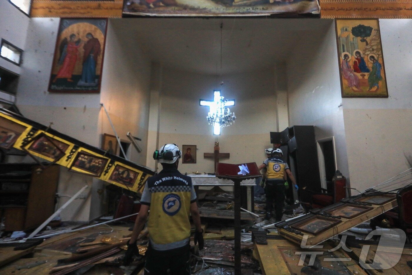 본문 이미지 - 22일&#40;현지시간&#41; 시리아 다마쿠스 드퀠라 지역의 성 엘리아스 교회에서 발생한 자살 폭탄 테러 현장에서 구조대원 등이 피해상황을 조사하고 있다. ⓒ AFP=뉴스1