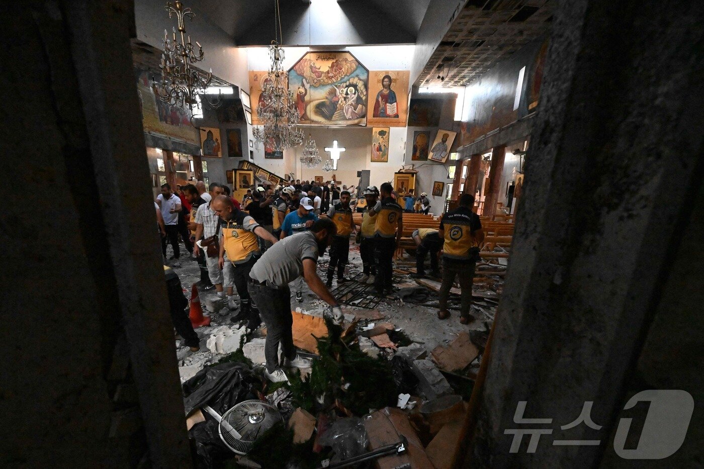 본문 이미지 - 22일&#40;현지시간&#41; 시리아 다마쿠스 드퀠라 지역의 성 엘리아스 교회에서 발생한 자살 폭탄 테러 현장에서 구조대원 등이 피해상황을 조사하고 있다.  ⓒ AFP=뉴스1