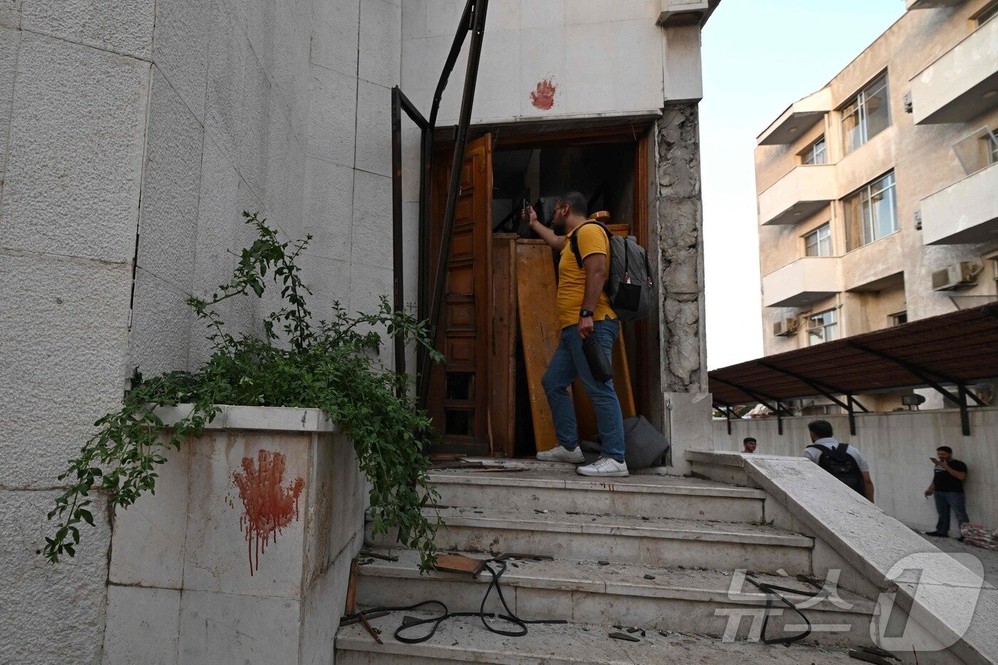 본문 이미지 - 22일&#40;현지시간&#41; 시리아 다마쿠스 드퀠라 지역의 성 엘리아스 교회에서 발생한 자살 폭탄 테러 현장에서 구조대원 등이 피해상황을 조사하고 있다. ⓒ AFP=뉴스1