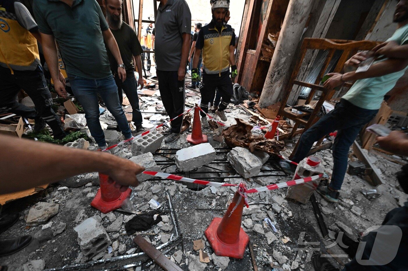 본문 이미지 - 22일&#40;현지시간&#41; 시리아 다마쿠스 드퀠라 지역의 성 엘리아스 교회에서 발생한 자살 폭탄 테러 현장에서 구조대원 등이 피해상황을 조사하고 있다.  ⓒ AFP=뉴스1