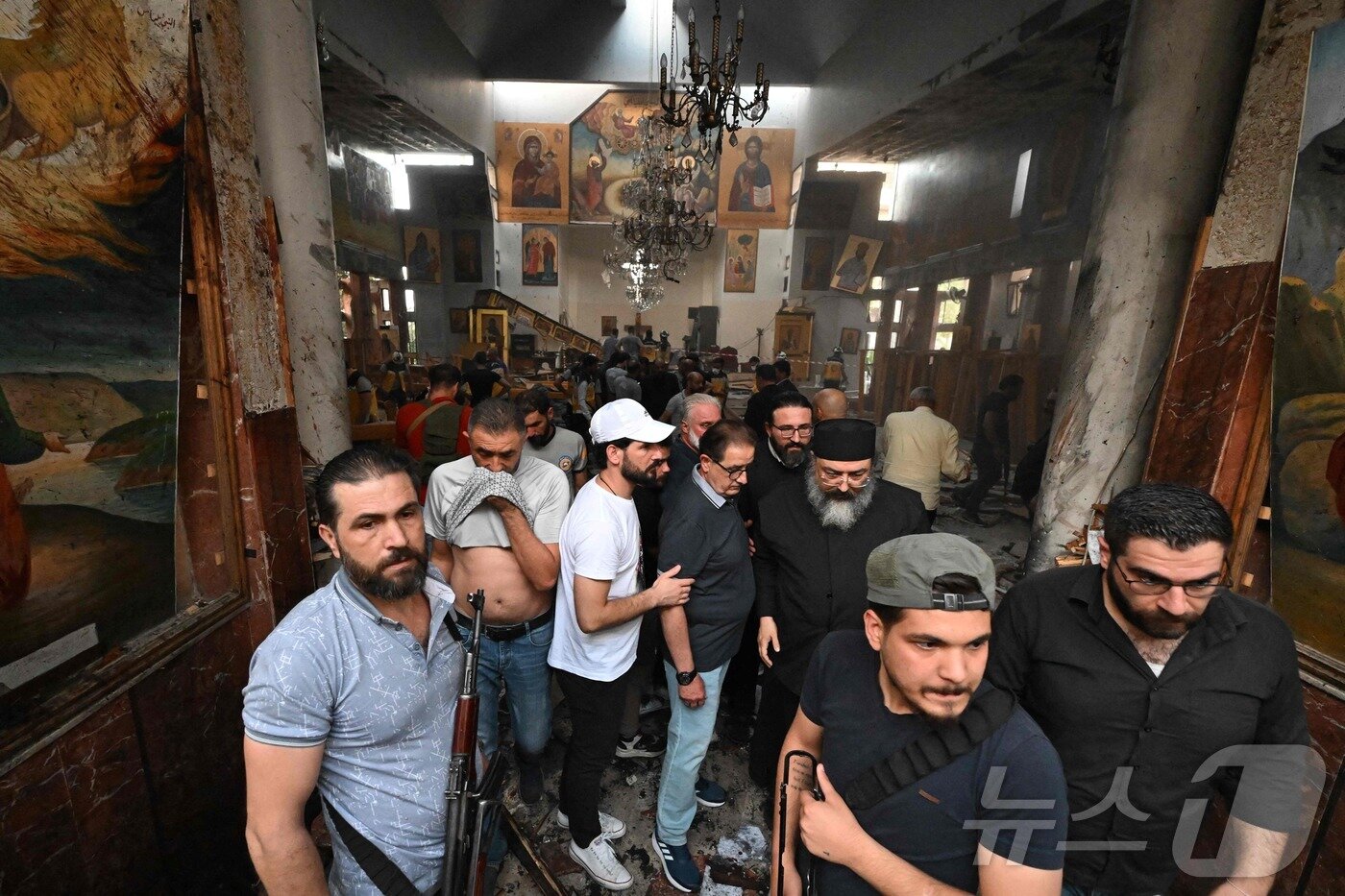 본문 이미지 - 22일&#40;현지시간&#41; 시리아 다마쿠스 드퀠라 지역의 성 엘리아스 교회에서 발생한 자살 폭탄 테러 현장에서 구조대원 등이 피해상황을 조사하고 있다. ⓒ AFP=뉴스1