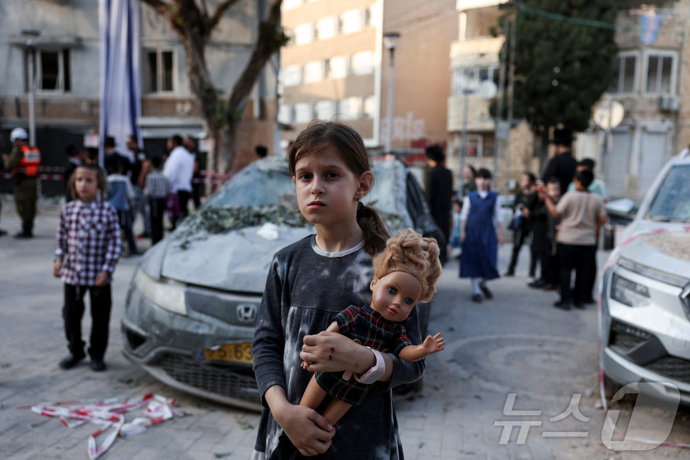 (하이파 로이터=뉴스1) 김경민 기자 = 이란의 공격을 당한 이스라엘 하이파 지역에서 소녀가 인형을 들고 있다. 2025.6.22ⓒ 로이터=뉴스1