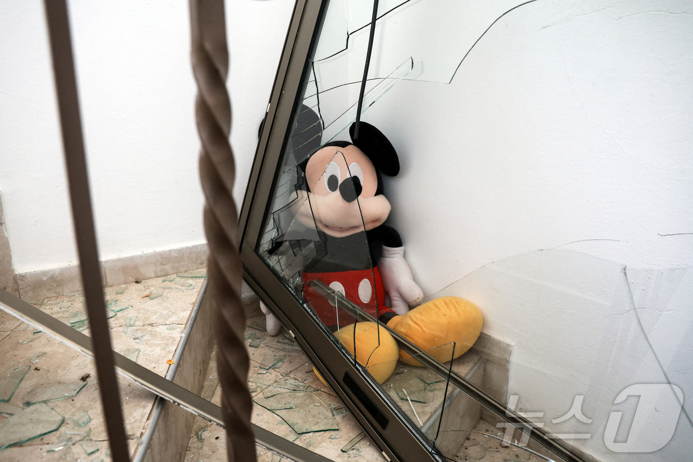 (텔아비브 로이터=뉴스1) 강민경 기자 = 이스라엘 텔아비브의 한 주택에서 22일(현지시간) 이란의 미사일 공격으로 깨진 유리창 안으로 미키마우스 인형이 보인다. 2025.6.22 …