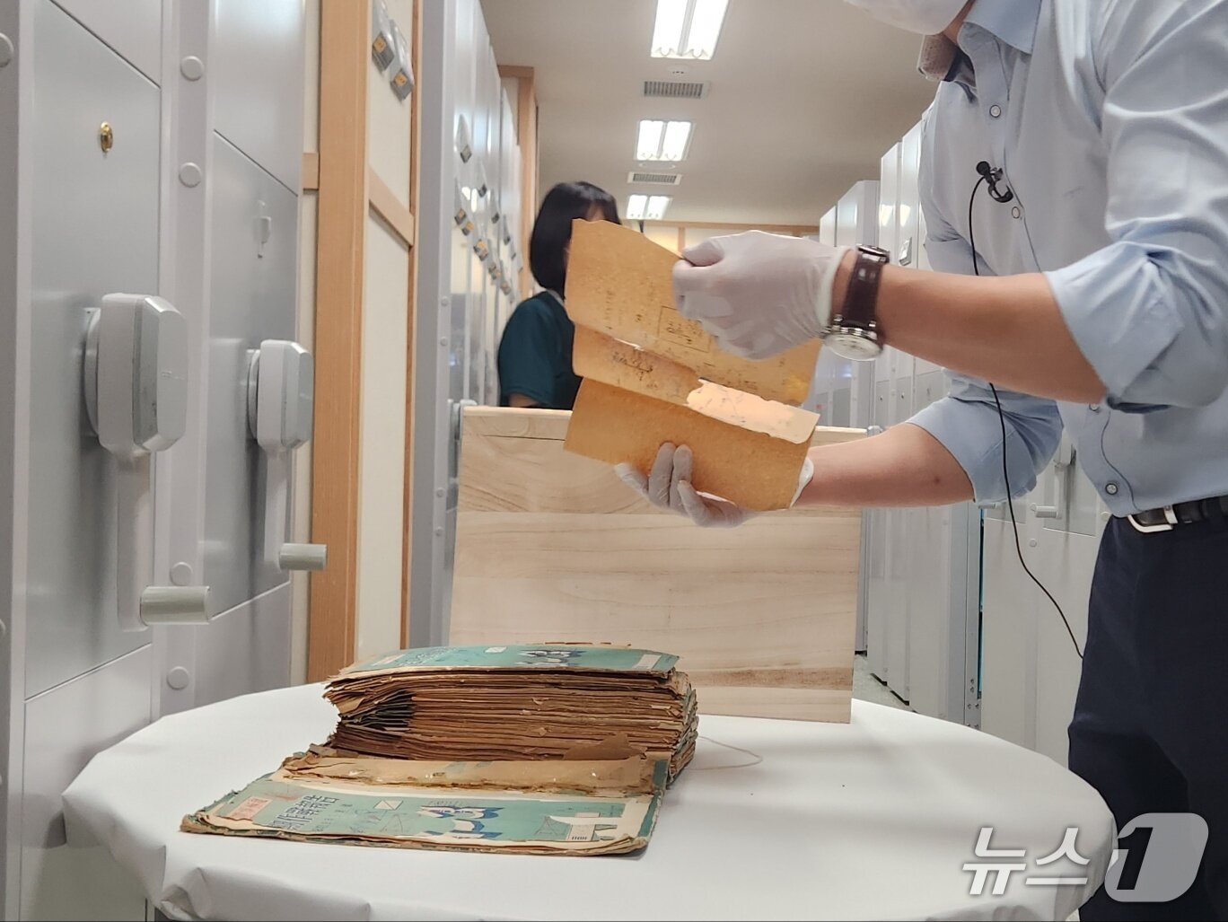 본문 이미지 - 육군기록정보관리단 관계자가 취재진에게 복원 전 기록물을 공개하고 있다. 2025.06.23 ⓒ 뉴스1 김예원 기자