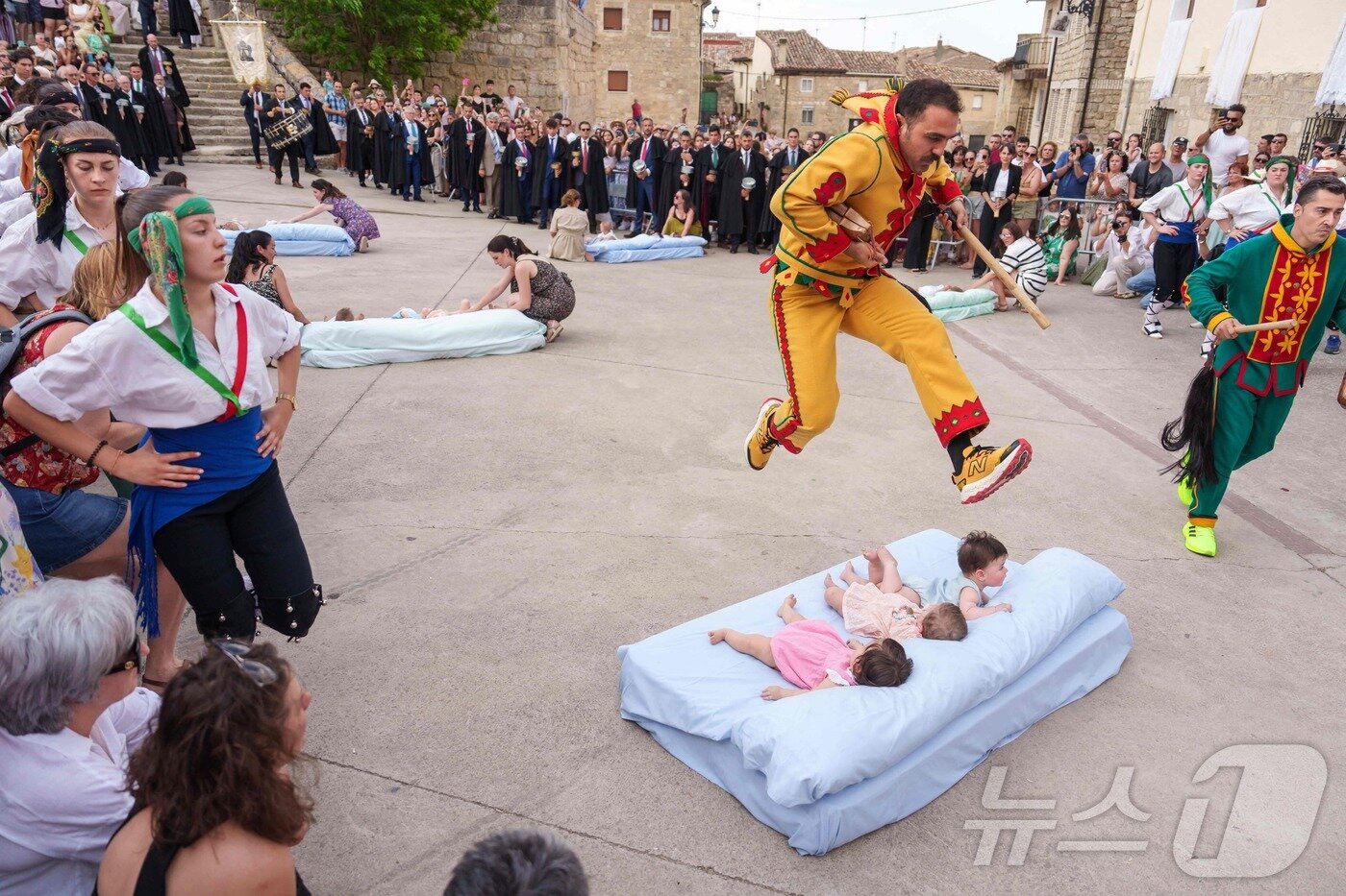 본문 이미지 - 22일(현지시간) 스페인 부르고스 인근 카스트리요 드 무르시아 마을에서 열린 '엘 콜라초(El Colacho)'축제에서 악마를 상징하는 '콜라초'가 아기들을 뛰어넘고 있다.ⓒ AFP=뉴스1