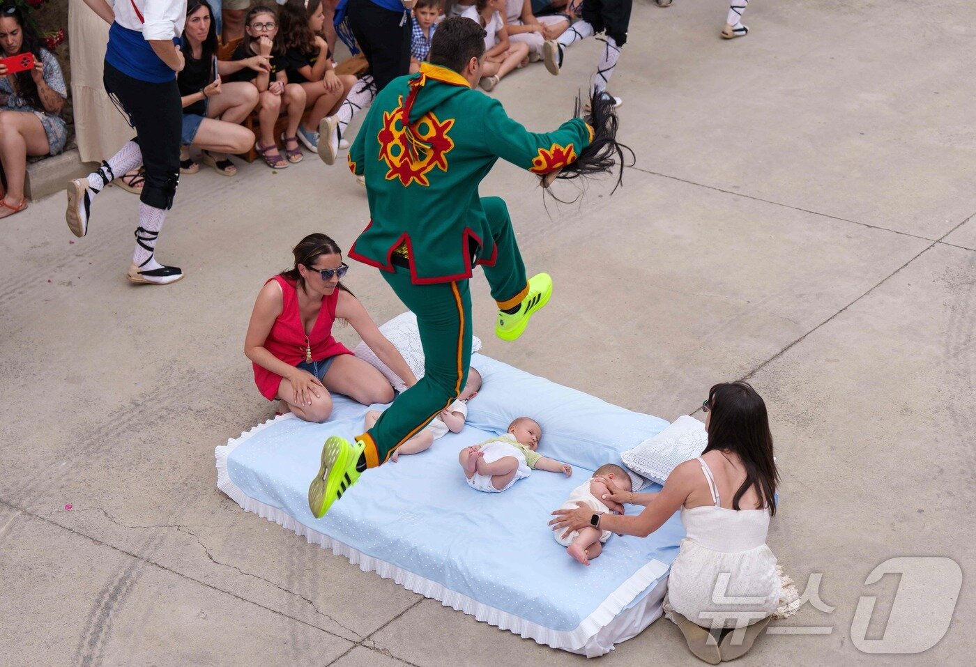 본문 이미지 - 22일(현지시간) 스페인 부르고스 인근 카스트리요 드 무르시아 마을에서 열린 '엘 콜라초(El Colacho)'축제에서 악마를 상징하는 '콜라초'가 아기들을 뛰어넘고 있다.ⓒ AFP=뉴스1