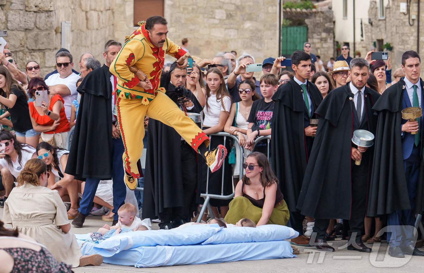 본문 이미지 - 22일(현지시간) 스페인 부르고스 인근 카스트리요 드 무르시아 마을에서 열린 '엘 콜라초(El Colacho)'축제에서 악마를 상징하는 '콜라초'가 아기들을 뛰어넘고 있다.ⓒ AFP=뉴스1