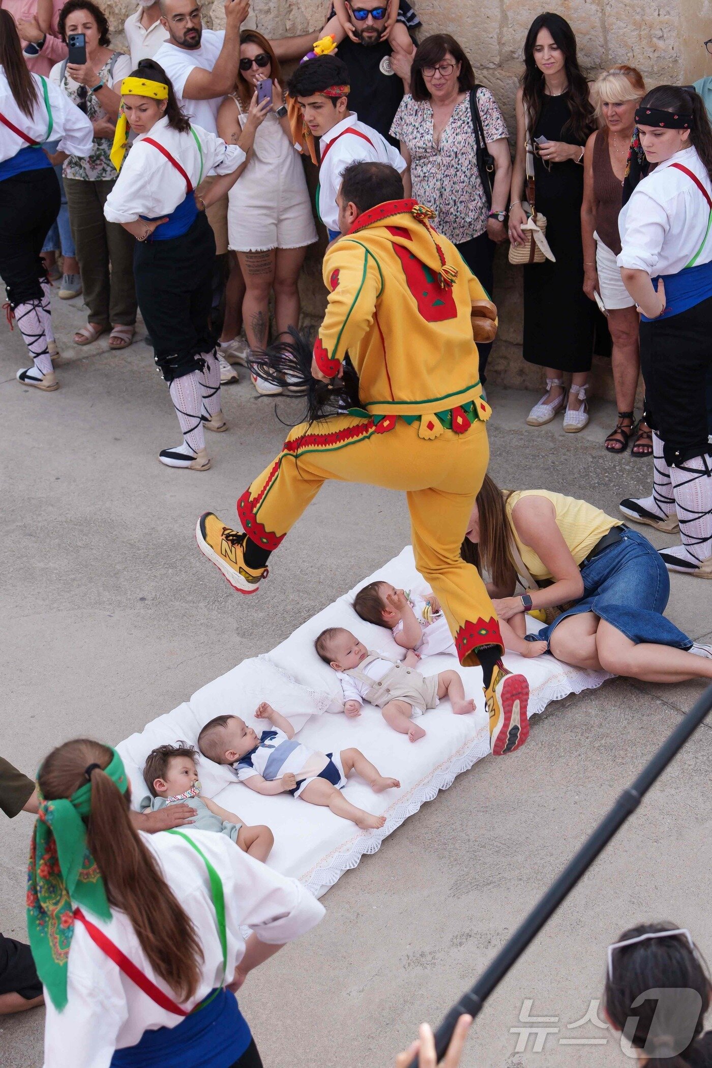 본문 이미지 - 22일(현지시간) 스페인 부르고스 인근 카스트리요 드 무르시아 마을에서 열린 '엘 콜라초(El Colacho)'축제에서 악마를 상징하는 '콜라초'가 아기들을 뛰어넘고 있다.ⓒ AFP=뉴스1
