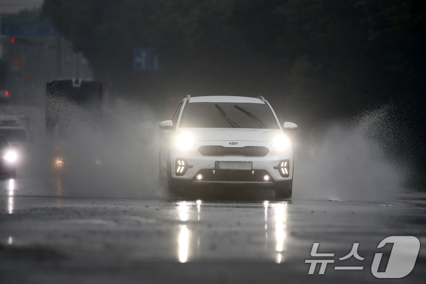 (대구=뉴스1) 공정식 기자 = 24일 오후 장맛비가 내리는 대구 달성군 다사읍 방천리 인근 도로에서 빗물이 고인 물웅덩이를 지나는 차량이 물보라를 일으키며 달리고 있다. 2025 …