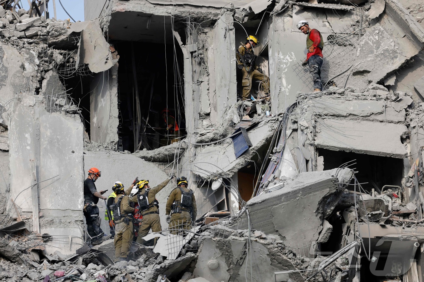 (베르셰바 AFP=뉴스1) 송송이 기자 = 24일(현지시간) 이스라엘 남부 베르셰바에서 이란의 미사일 공격으로 파괴된 건물을 긴급 구조대원들이 점검하고 있다. 2025.06.24ⓒ …