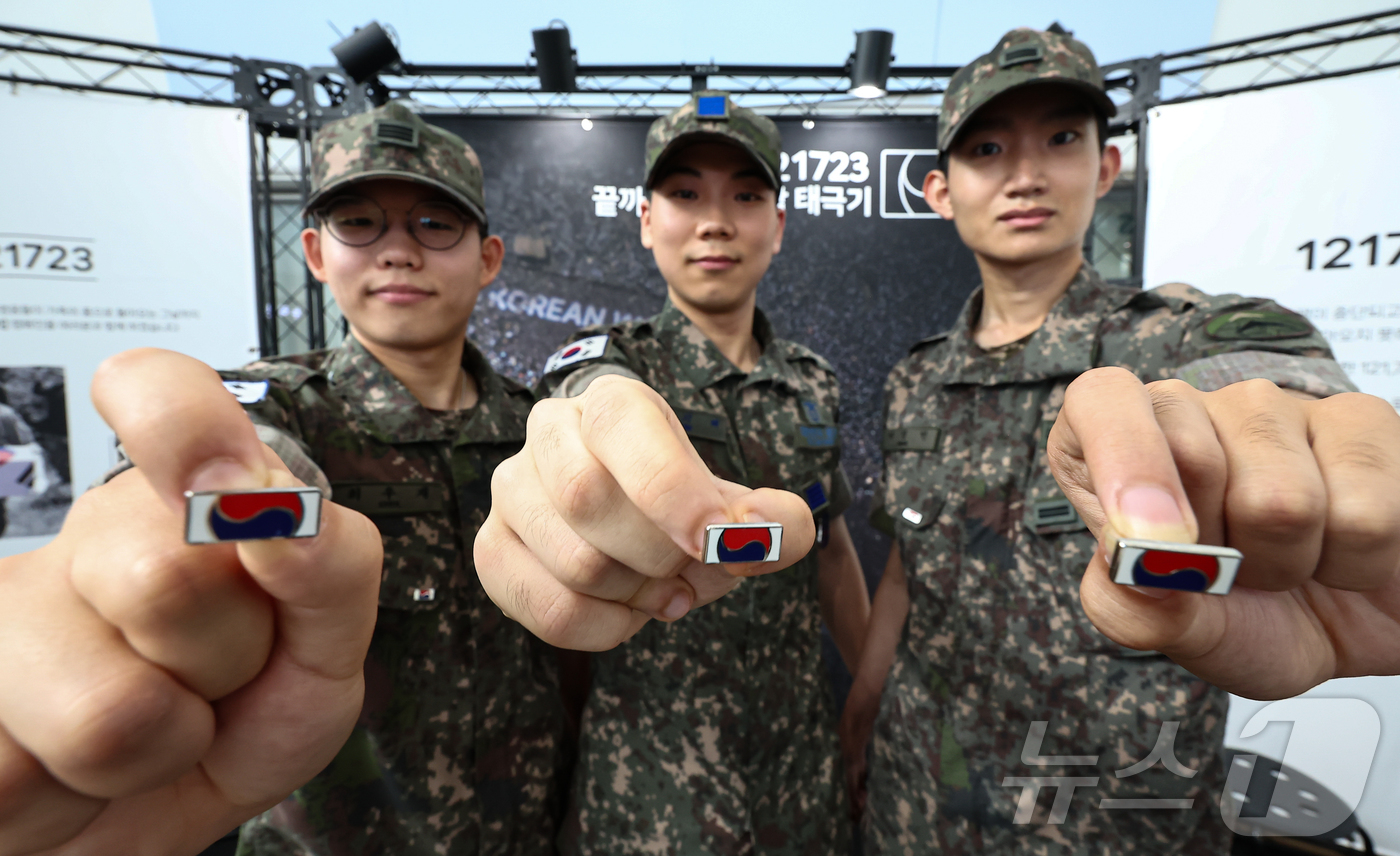 (서울=뉴스1) 김도우 기자 = 25일 서울 중구 서울역 대합실에 마련된 '태극기 부스'에서 군인들이 태극기 배지를 들어보이고 있다.국가보훈부는 이날 10시부터 20시까지 이곳에 …