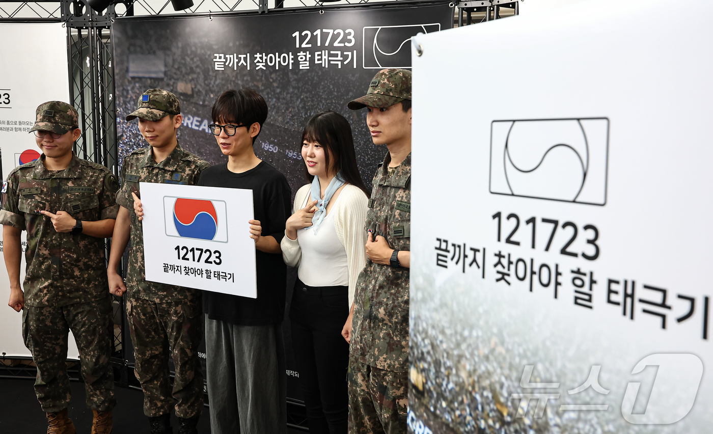 (서울=뉴스1) 김도우 기자 = 25일 서울 중구 서울역 대합실에 마련된 '태극기 부스'에서 군인들과 시민들이 태극기 배지를 패용 후 기념촬영 하고 있다.국가보훈부는 이날 10시부 …