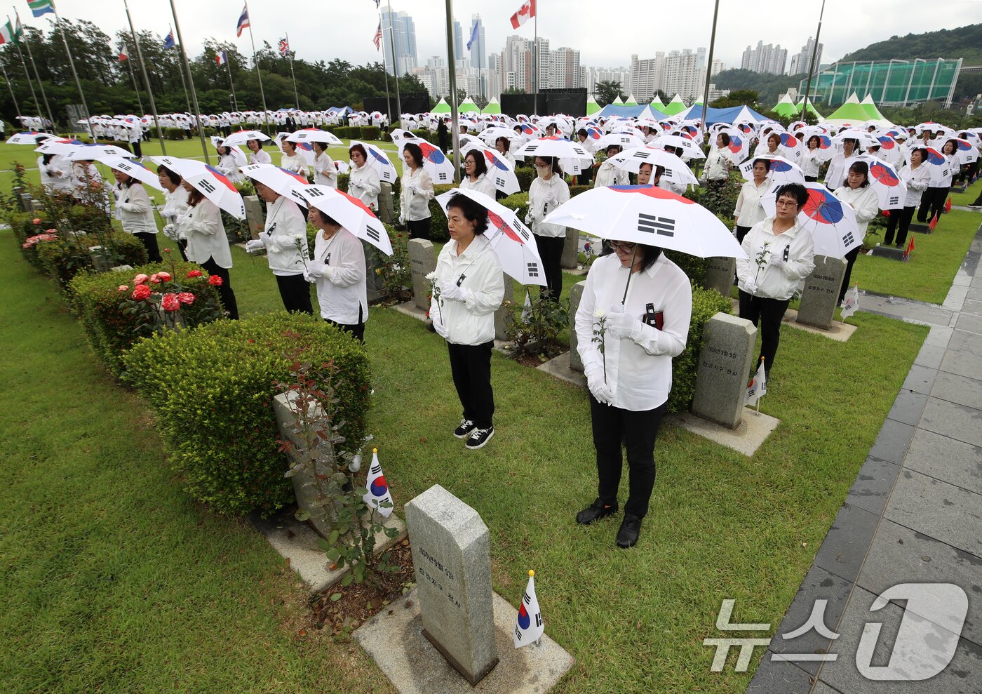 본문 이미지 - 25일 오전 부산 남구 유엔기념공원에서 열린 제75주년 6·25전쟁 참전 유엔전몰용사 추모제에서 태극기 우산을 쓴 참석자들이 유엔군 전몰장병 묘역을 참배하고 있다. 2025.6.25/뉴스1 ⓒ News1 윤일지 기자