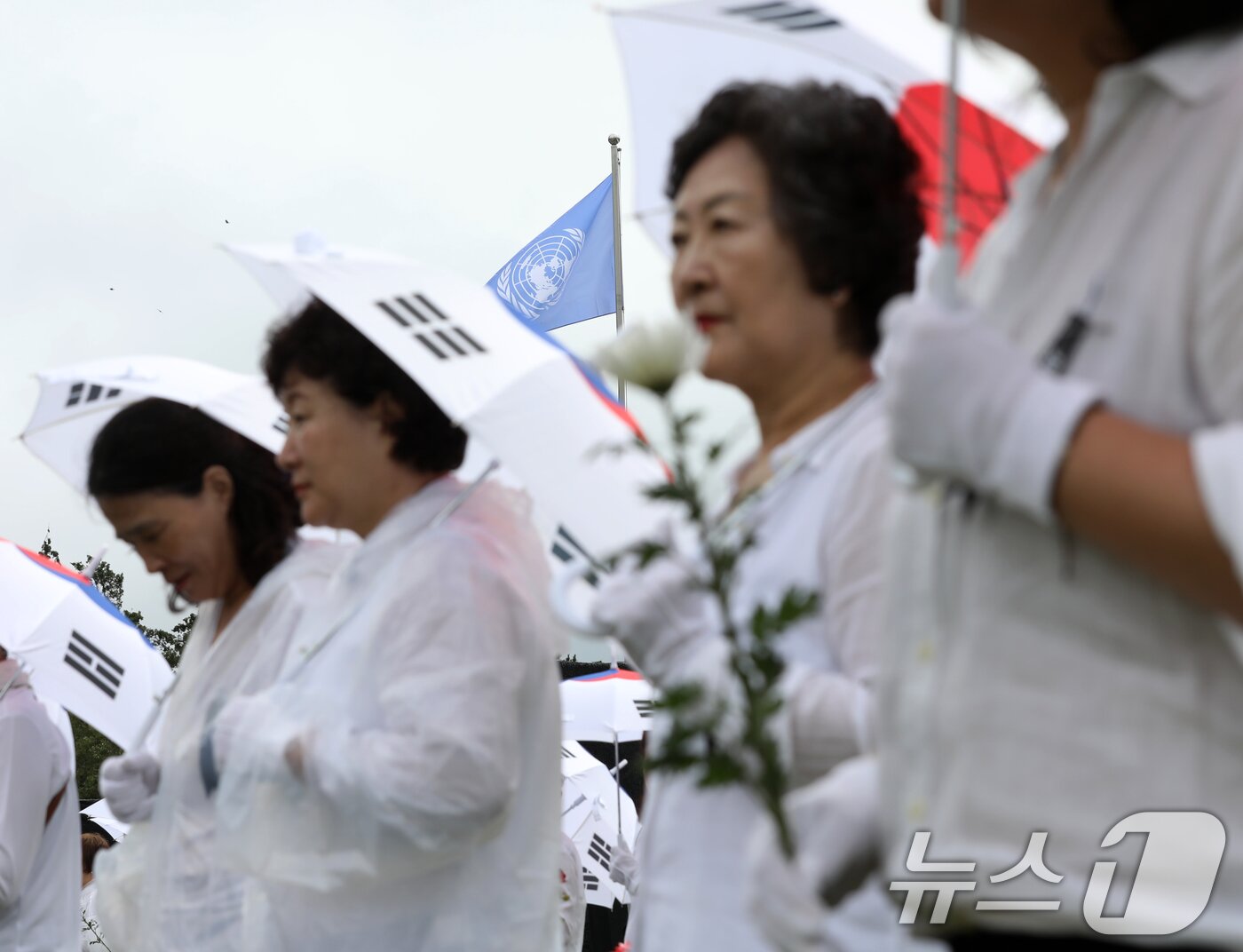 본문 이미지 - 25일 오전 부산 남구 유엔기념공원에서 열린 제75주년 6·25전쟁 참전 유엔전몰용사 추모제에서 태극기 우산을 쓴 참석자들이 유엔군 전몰장병 묘역을 참배하고 있다. 2025.6.25/뉴스1 ⓒ News1 윤일지 기자