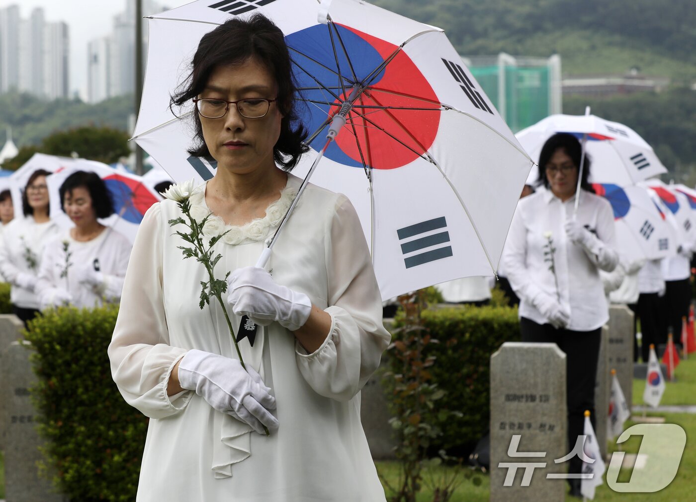 본문 이미지 - 25일 오전 부산 남구 유엔기념공원에서 열린 제75주년 6·25전쟁 참전 유엔전몰용사 추모제에서 태극기 우산을 쓴 참석자들이 유엔군 전몰장병 묘역을 참배하고 있다. 2025.6.25/뉴스1 ⓒ News1 윤일지 기자