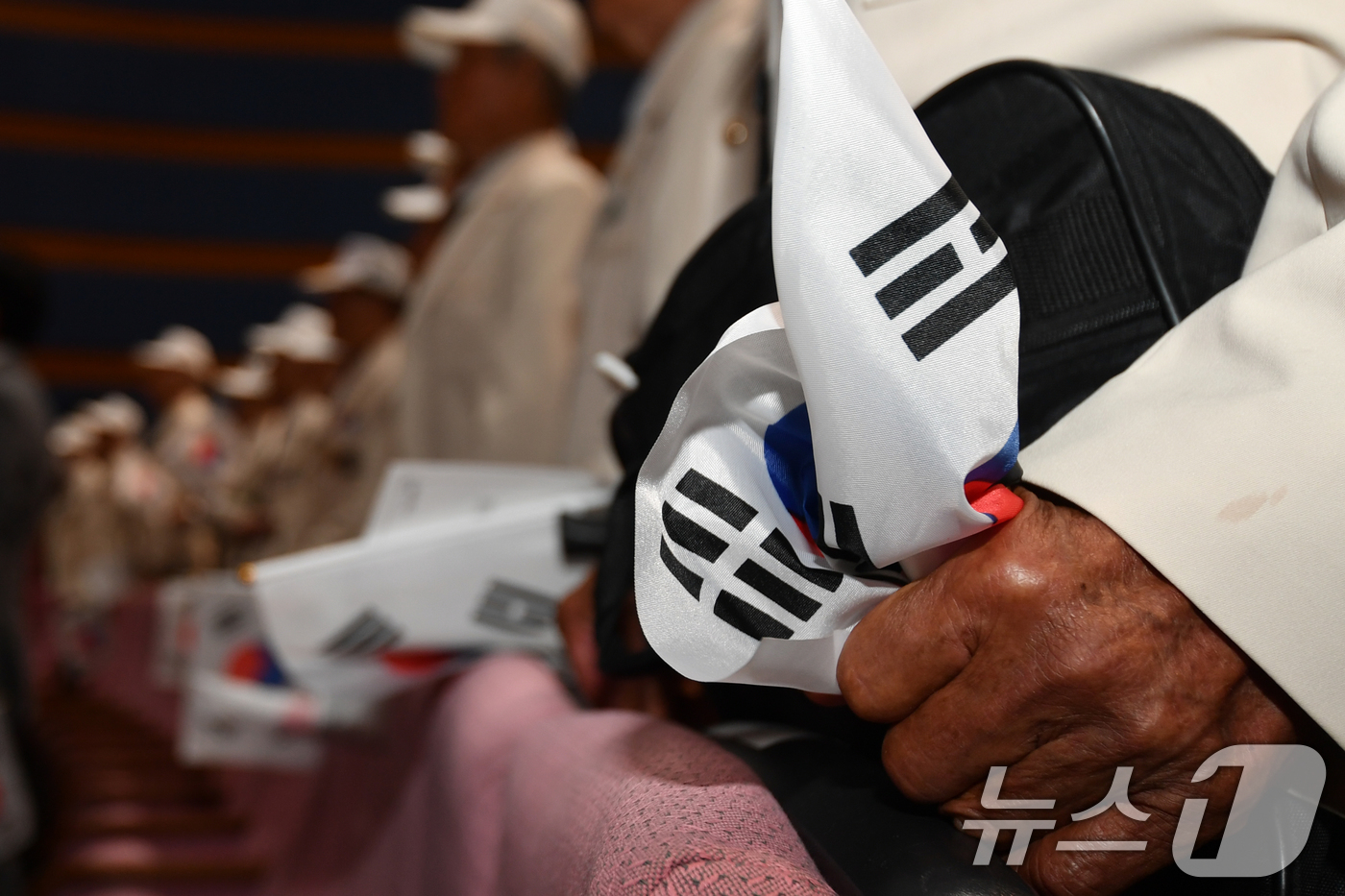 (포항=뉴스1) 최창호 기자 = 25일 경북 포항시청 대잠홀에서 열린 6.25전쟁 75주년 기념식에서 전쟁에 참전했던 노병이 태극기를 꼭 잡은채 애국가를 제창하고 있다.   202 …