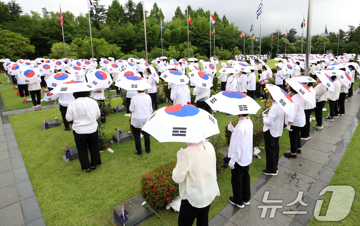 본문 이미지 - 25일 오전 부산 남구 유엔기념공원에서 열린 제75주년 6·25전쟁 참전 유엔전몰용사 추모제에서 태극기 우산을 쓴 참석자들이 유엔군 전몰장병 묘역을 참배하고 있다. 2025.6.25/뉴스1 ⓒ News1 윤일지 기자