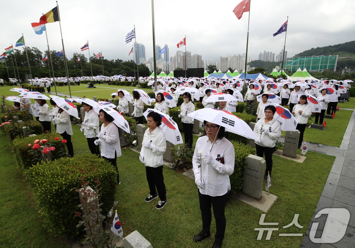 본문 이미지 - 25일 오전 부산 남구 유엔기념공원에서 열린 제75주년 6·25전쟁 참전 유엔전몰용사 추모제에서 태극기 우산을 쓴 참석자들이 유엔군 전몰장병 묘역을 참배하고 있다. 2025.6.25/뉴스1 ⓒ News1 윤일지 기자